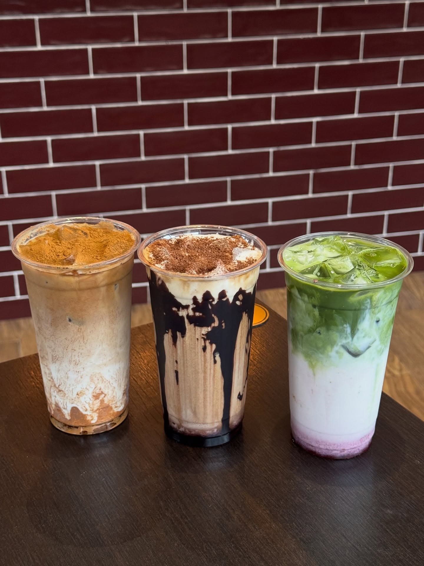 Three Hidden Gem iced drinks including a layered matcha, on the counter