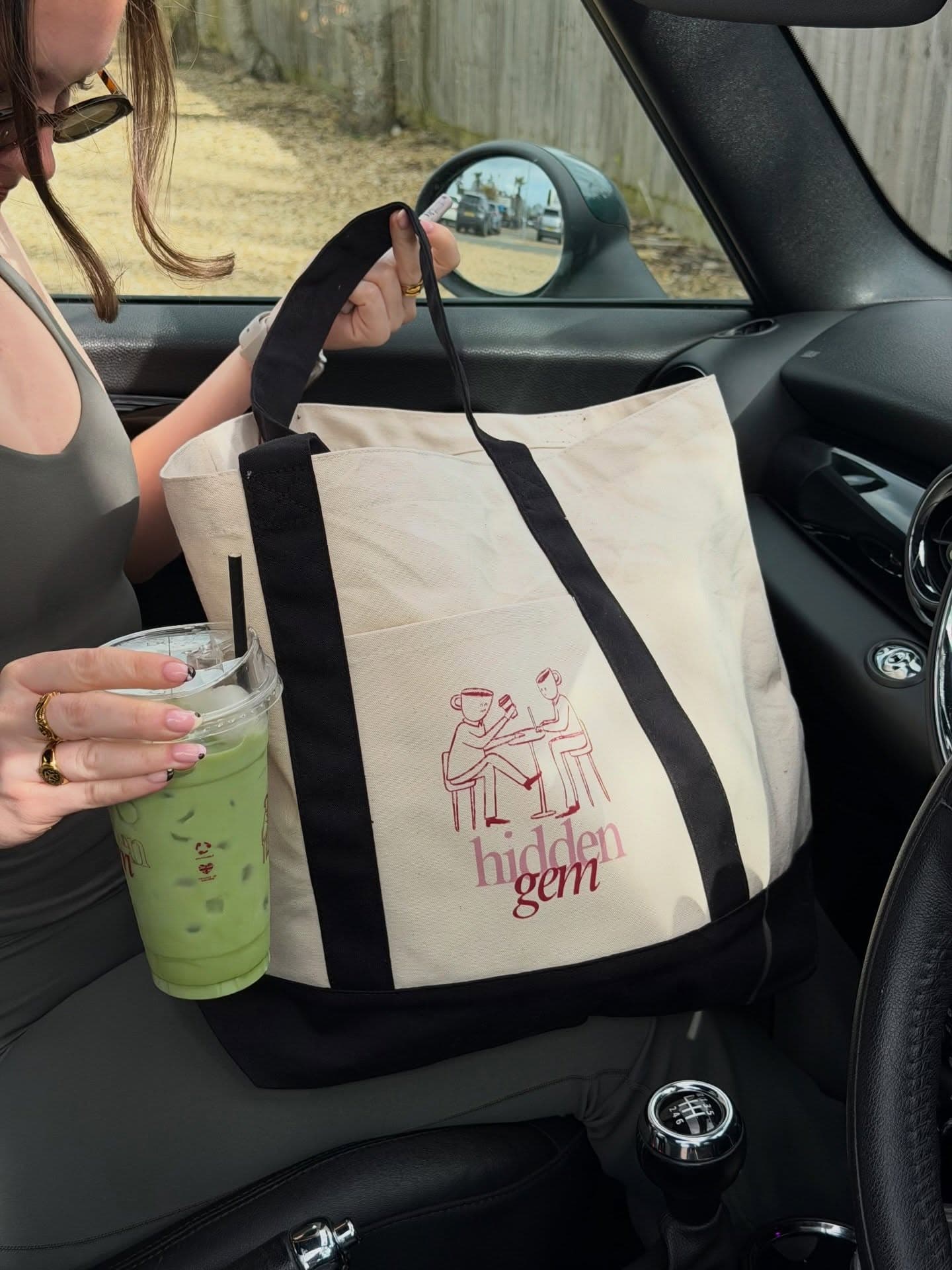 A Hidden Gem tote bag and an iced matcha