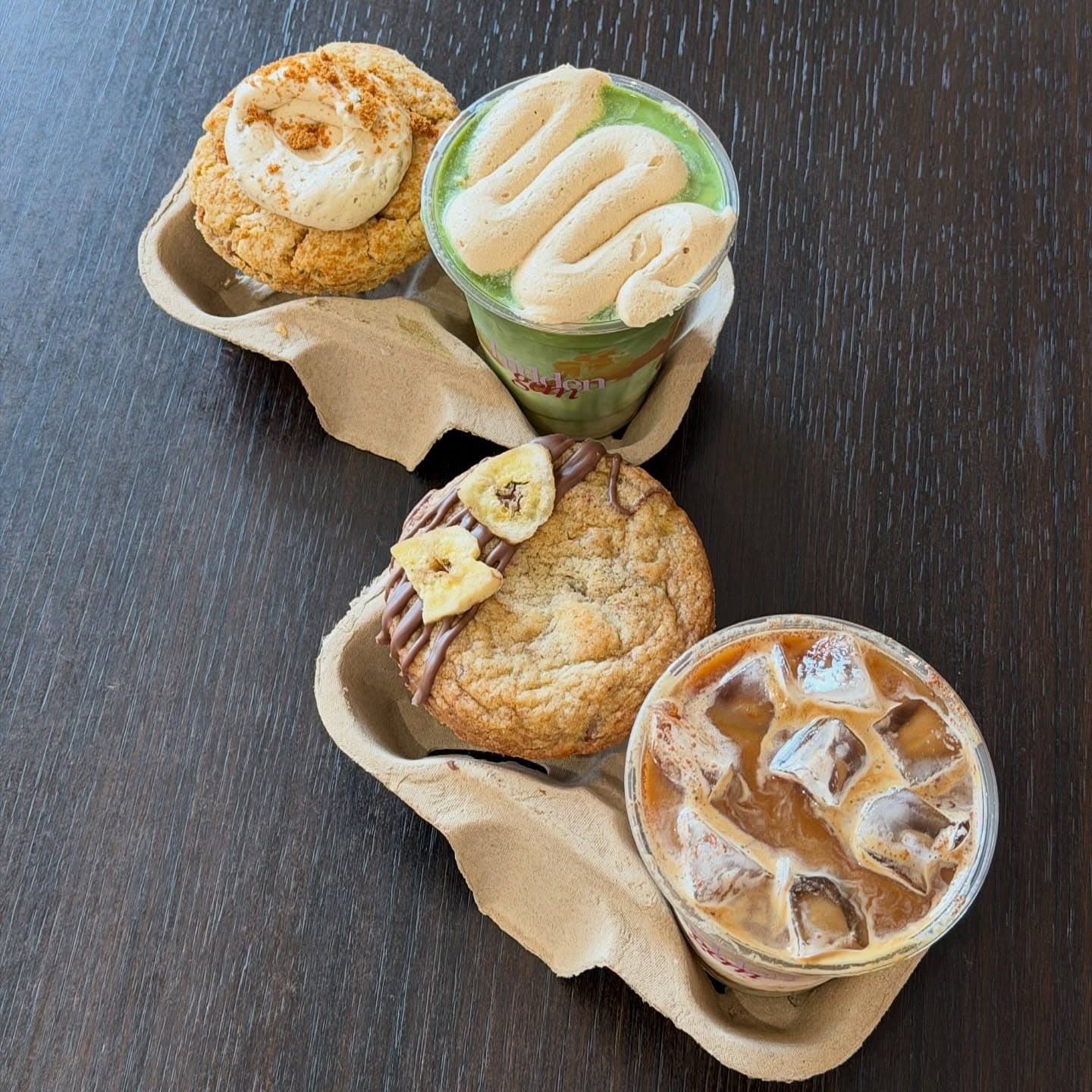 Cookies and iced drinks arranged in a takeaway carrier