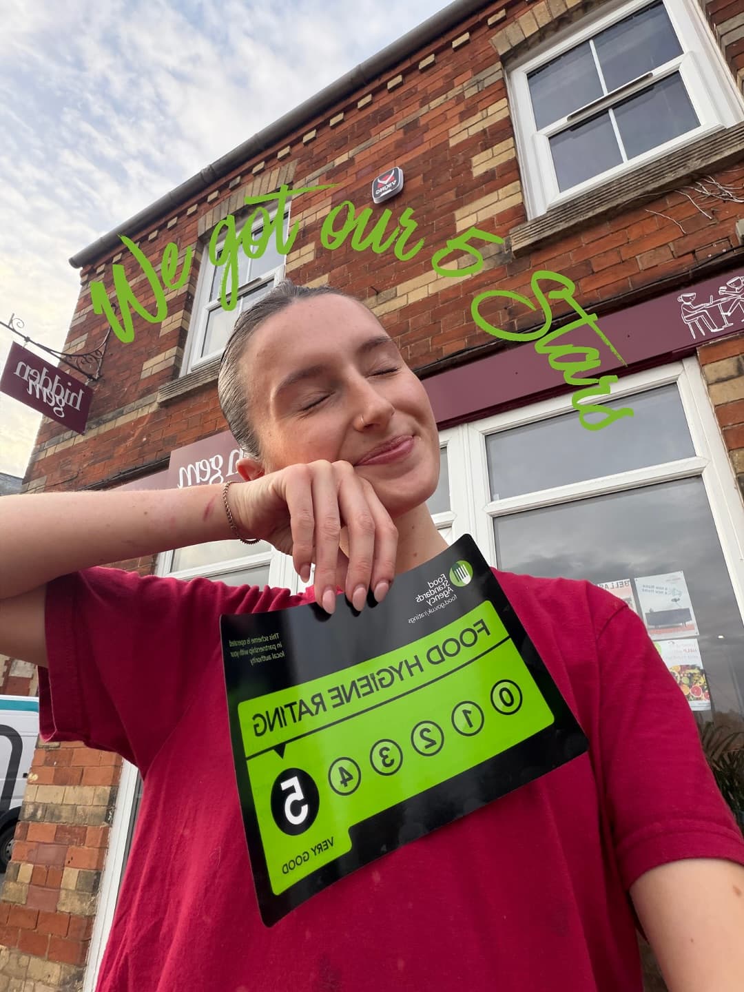 Gem, the owner of Hidden Gem, outside the café holding its 5-star food hygiene certificate